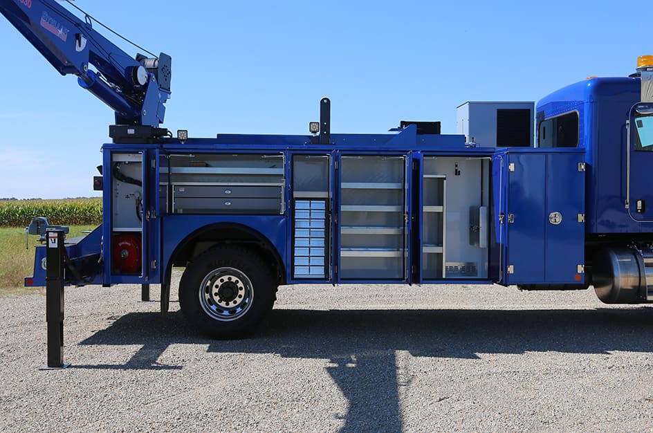 A closeup of the open compartment doors on a blue TMAX 3 mechanic truck