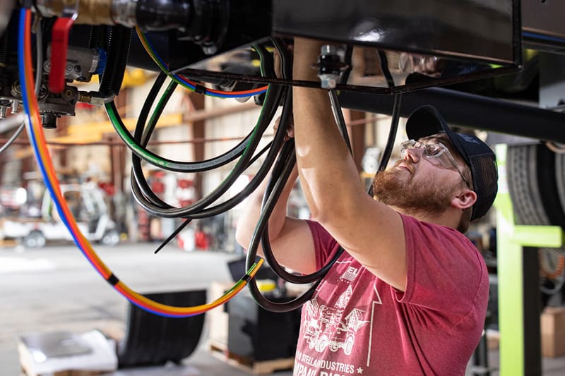 Stellar employee working to connect wire on a vehicle that is on a lift