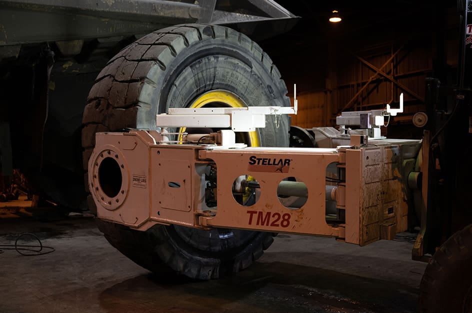 TM28 Tire Manipulator changing tire on dumptruck, close-up