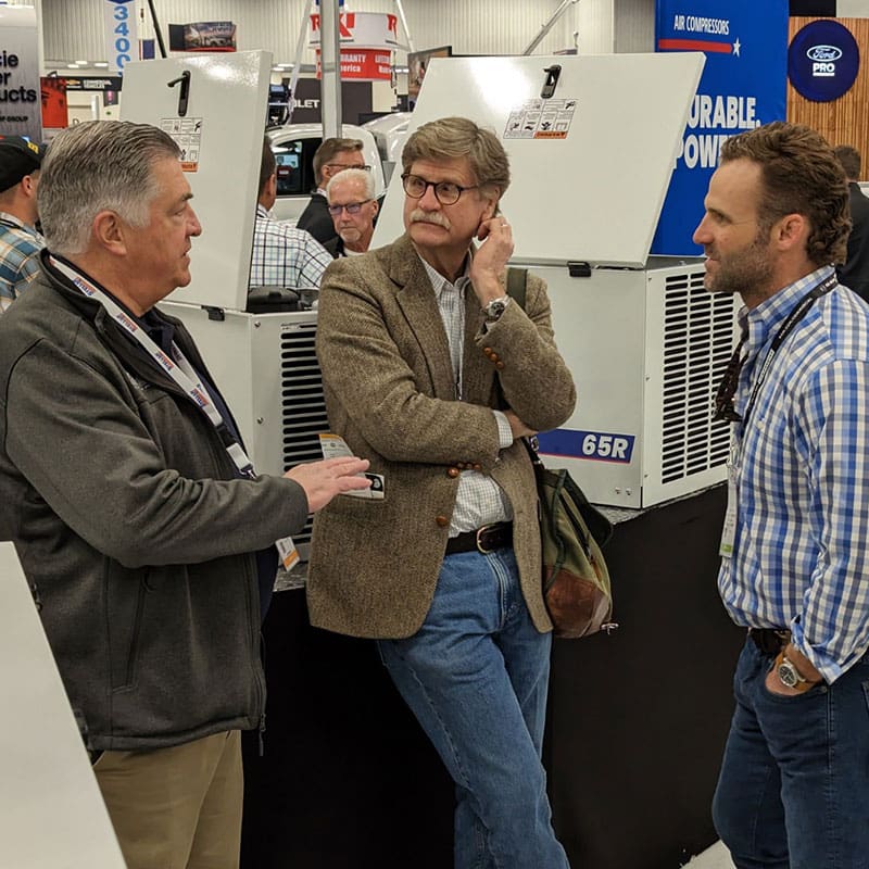 Stellar Rep speaking with visitors about compressors — 65R is on display in the background
