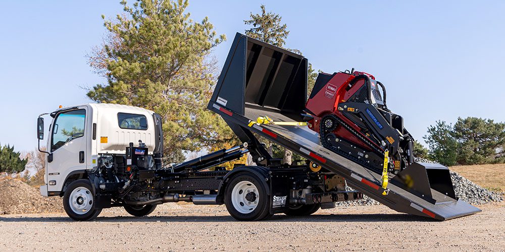 NXT18 Hooklift with a Toro Dingo strapped to a flatbed.