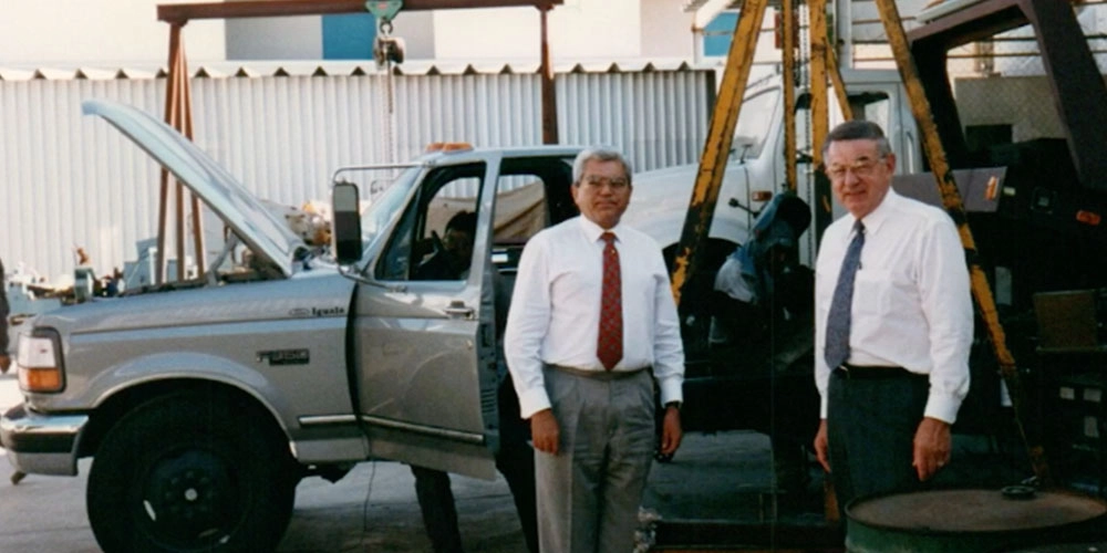 Francis and a customer in front of a early version of the hooklift.