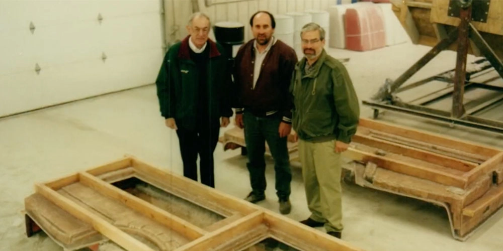 Francis, Gary and another co-worker on the shop floor standing near a prototype.