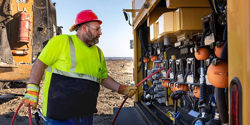 Waste Innovations technician with an off-road TA fuel lube truck in a remote location.