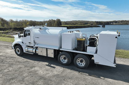 Fuel & Lube truck with a lake in the background and a partly cloudy sky